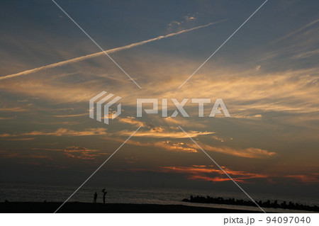 夕暮れをバックに幸せそうな家族 夕暮れをバックに幸せそうな家族 94097040