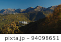 Amazing aerial view from funicular cabin on rosa khutor village. the rays of the sun fall on the beautiful caucasus mountains covered with autumn colorful trees. 94098651