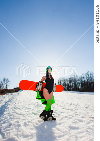 Young beautiful woman posing with a snowboard on a ski slope 94101166
