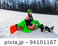 Young beautiful woman posing with a snowboard on a ski slope 94101167