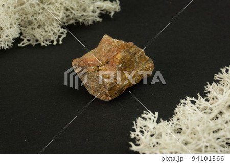 Andalusite from Brazil or China. Natural mineral stone on a black background surrounded by moss. Mineralogy, geology, magic, semi-precious stones and samples of minerals. Close-up macro photo 94101366