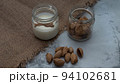 World Vegan Day concept. Nut milk in glass jar with almond. Homemade alternative dairy product. Plant based, lactose free. Selective focus 94102681