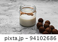 World Vegan Day concept. Nut milk in glass jar with macadamia. Homemade alternative dairy product. Plant based, lactose free. Selective focus 94102686