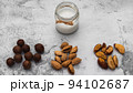 World Vegan Day concept. Nut milk in glass jar with almond, macadamia, brazil nuts. Homemade alternative dairy product. Plant based, lactose free. Tasty and healthy. Selective focus 94102687