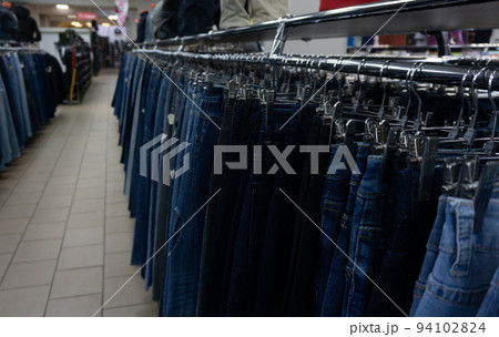 Jeans in the mall hang on hangers. Large selection of denim clothing 94102824