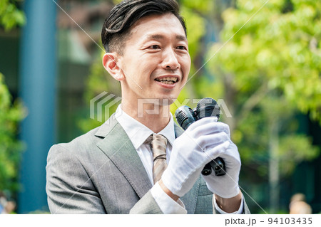 マイクを使って街頭で主張を訴える男性 94103435