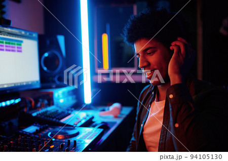 Glad music producer listening new track in headphones Glad music producer listening new track in headphones 94105130