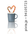 Cocoa with marshmallows and two heart-shaped Candy canes in a gray cup isolated on a white background with reflection. A Christmas gift, a traditional drink for a cozy winter evening. 94105723