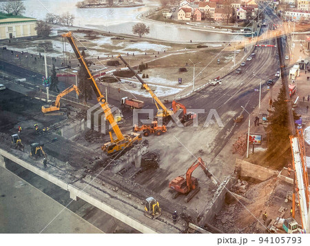 construction of a bridge in the city center. construction of a new overpass on a fenced section of the road. view from a height of a large construction site 94105793