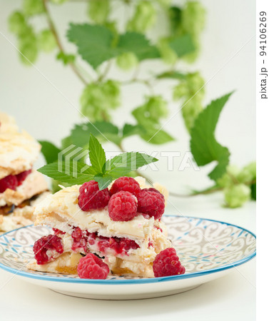 Round meringue pie with fresh raspberries on a white background, Pavlova dessert 94106269