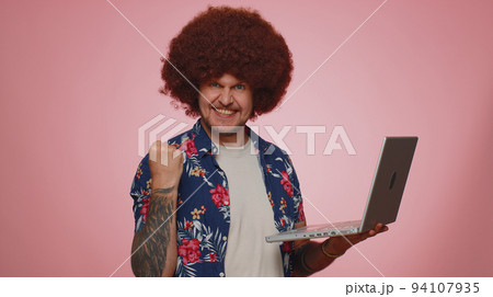 Excited happy man working on laptop computer winning lottery, celebrating success, online shopping Excited happy man working on laptop computer winning lottery, celebrating success, online shopping 94107935