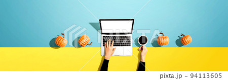 Autumn pumpkins with person using a laptop computer 94113605
