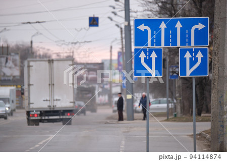 Traffic sign pointing multiple road lanes direction on city street. Signboard arrows for urban transport safety guidance 94114874