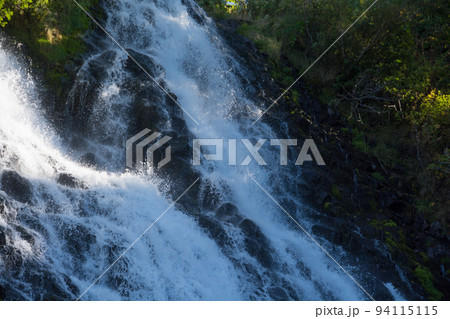 木々の間を流れ落ちる滝 94115115