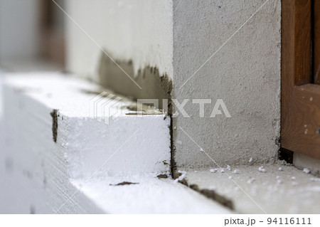 Close-up detail of plastered house wall with rigid styrofoam insulation. Modern technology, construction, renovation, energy saving, alternative for mineral wool, warm comfortable house concept. 94116111
