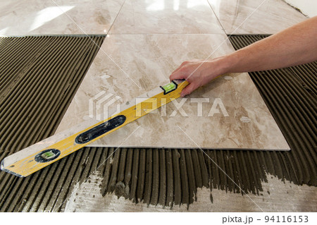 Ceramic tiles and tools for tiler. Floor tiles installation. Home improvement, renovation - ceramic tile floor adhesive, mortar, level 94116153