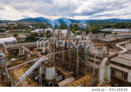 Aerial view of wood processing plant with smokestack from production process polluting environment at factory manufacturing yard Aerial view of wood processing plant with smokestack from production process polluting environment at factory manufacturing yard 94116636