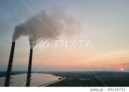 Aerial view of coal power plant high pipes with black smokestack polluting atmosphere. Electricity production with fossil fuel concept Aerial view of coal power plant high pipes with black smokestack polluting atmosphere. Electricity production with fossil fuel concept 94116731