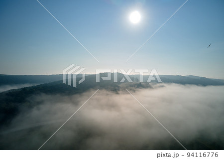 Aerial view from high altitude of earth covered with white puffy cumulus clouds on sunny day 94116776