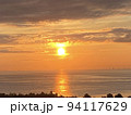 朝日に照らされた海に映る光の道 94117629