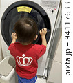 ドラム式洗濯機の中を扉越しに見る子供（危ないシーン） 94117633