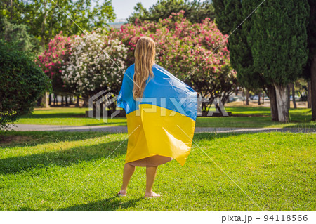 A woman put a Ukrainian flag on his shoulders. concept Ukrainian patriot, rally in support of Ukraine Portrait of a disgruntled girl sitting at a cafe table A woman put a Ukrainian flag on his shoulders. concept Ukrainian patriot, rally in support of Ukraine Portrait of a disgruntled girl sitting at a cafe table 94118566