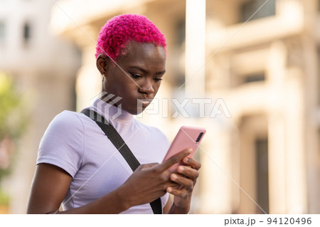 Serious african young woman using the mobile Serious african young woman using the mobile 94120496