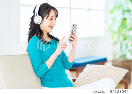 女性 リビング スマホ ヘッドホン ライフスタイル カジュアル 寝転ぶ 女性 リビング スマホ ヘッドホン ライフスタイル カジュアル 寝転ぶ 94123044