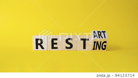 Restart and resting symbol. Turned cubes with words Resting and Restart. Beautiful yellow background. Business and Restart and resting concept. Copy space 94123714