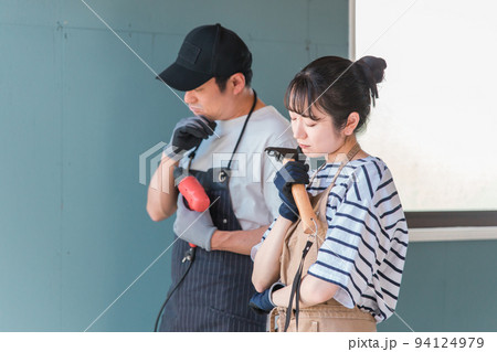 ガレージをDIY・リノベーションをする男女(困る) ガレージをDIY・リノベーションをする男女(困る) 94124979