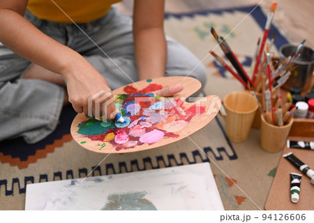 Happy young woman painting picture with watercolor at cozy home. Art, creative hobby and leisure activity concept 94126606