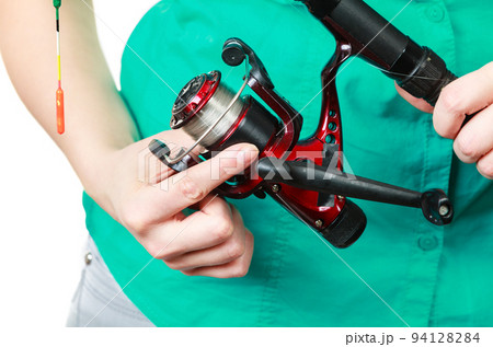 Person holding fishing rod, spinning equipment. Person holding fishing rod, spinning equipment. 94128284