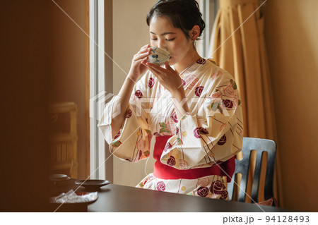 温泉旅館の客室でお茶を飲む浴衣姿の女性 94128493