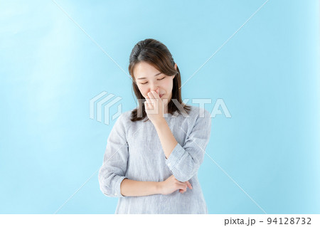 鼻を抑える女性　ブルーバック 94128732