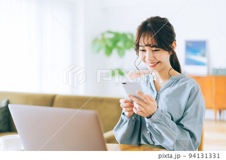 自宅でスマホとパソコンを使う女性 自宅でスマホとパソコンを使う女性 94131331