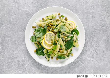 Pasta penne with spinach pesto and green peas Pasta penne with spinach pesto and green peas 94131385