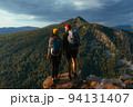 Travelers on the background of autumn mountains. Mountain tourism. Walking tour of the autumn mountains. A trip to the mountains with a backpack. A couple in love against the background of mountains 94131407