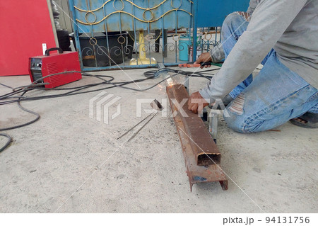 Construction worker welding Steel to build a roof structure 94131756