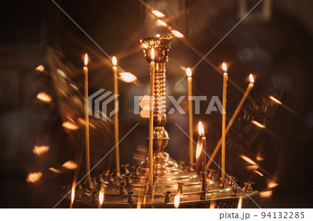 Burning wax candles in a Christian church 94132285