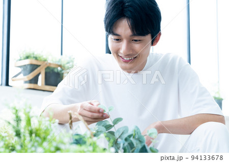 観葉植物を愛でる男性 94133678