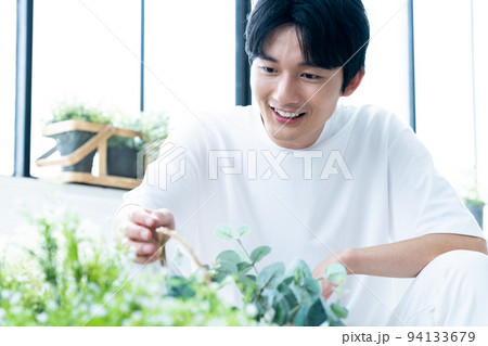観葉植物を愛でる男性 94133679