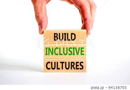 Build inclusive cultures symbol. Concept words Build inclusive cultures on wooden blocks. Businessman hand. Beautiful white background. Business build inclusive cultures concept. Copy space. Build inclusive cultures symbol. Concept words Build inclusive cultures on wooden blocks. Businessman hand. Beautiful white background. Business build inclusive cultures concept. Copy space. 94138703