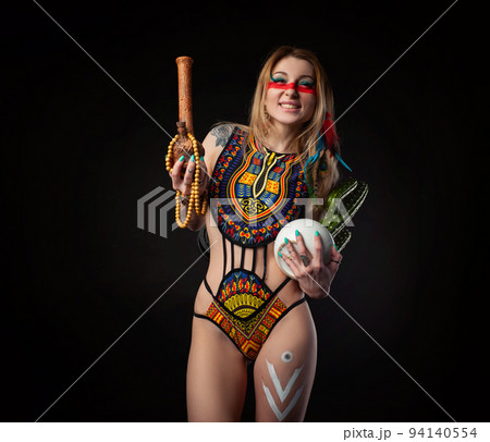 sexy hippie girl posing with bong for smoking marijuana in a bright swimsuit on a dark background 94140554