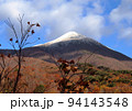 初冬、磐梯山の初冠雪と紅葉のなごりの葉とのコラボレーションが青空に綺麗 94143548