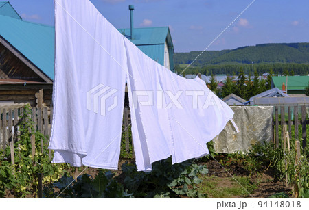 white linen hanging on a rope, on the street white linen hanging on a rope, on the street 94148018