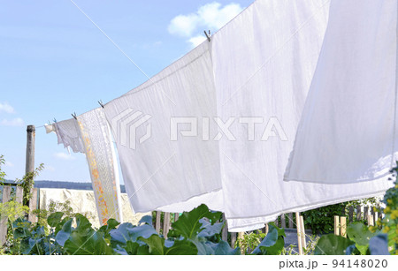 white linen hanging on a rope, on the street white linen hanging on a rope, on the street 94148020