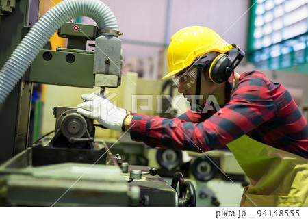 Factory workers place metal to drill by old manual machine 94148555