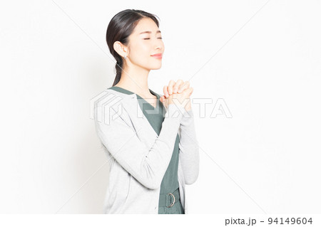 白背景の前で、お願いのポーズをする女性 白背景の前で、お願いのポーズをする女性 94149604