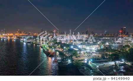 Aerial view of petrochemical oil refinery and sea in industrial engineering concept in Bangna district at night, Bangkok City, Thailand. Oil and gas tanks pipelines in industry. Modern metal factory. Aerial view of petrochemical oil refinery and sea in industrial engineering concept in Bangna district at night, Bangkok City, Thailand. Oil and gas tanks pipelines in industry. Modern metal factory. 94149940