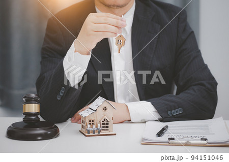 Male lawyer or judge delivering keys to customer. Real estate law and house auction concept. Male lawyer or judge delivering keys to customer. Real estate law and house auction concept. 94151046